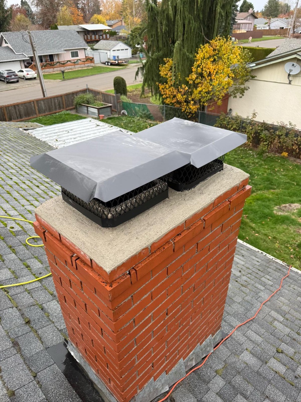 Twin chimney caps on a repointed chimney