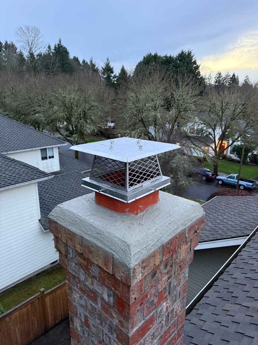 Stainless chimney cap on a fresh concrete crown